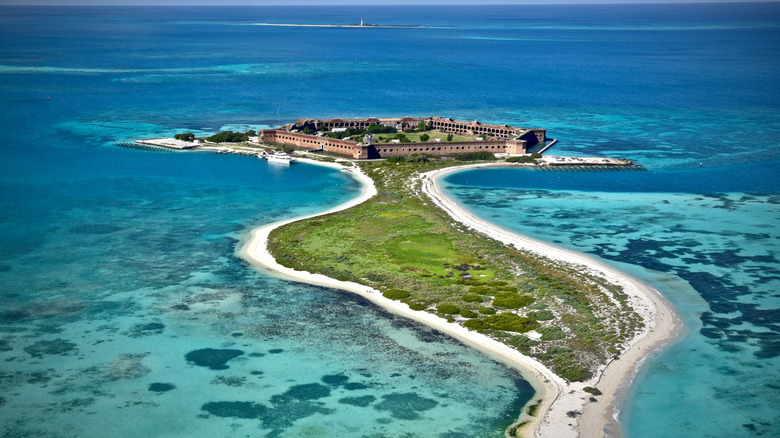 Aerial view of Fort Jefferson at Dry Tortugas National Park taken from a seaplane with brilliant blue water surrounding a small island where the fort is located