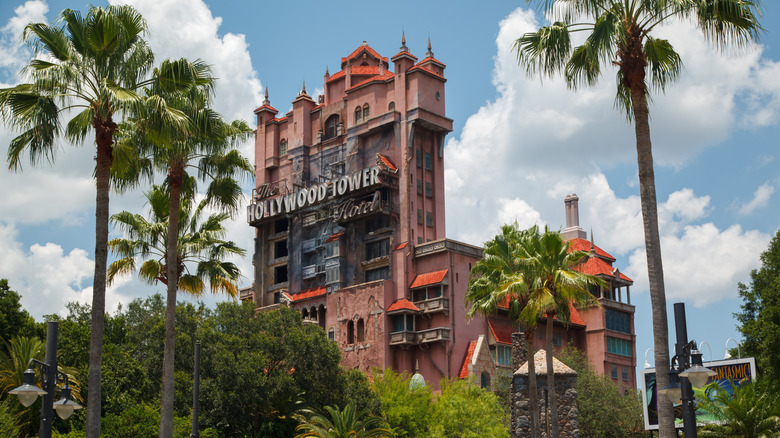 View of the Hollywood Tower Hotel Twilight Zone Tower of Terror ride at Disney's Hollywood Studios on a sunny day with palm trees in the foreground