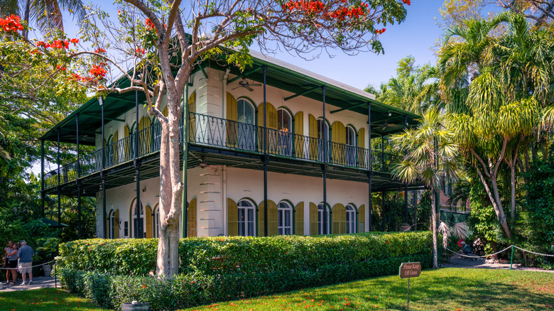 View of the Ernest Hemingway home in Key West. Beautiful, lime-colored villa in Spanish colonial style with tropical garden around it.