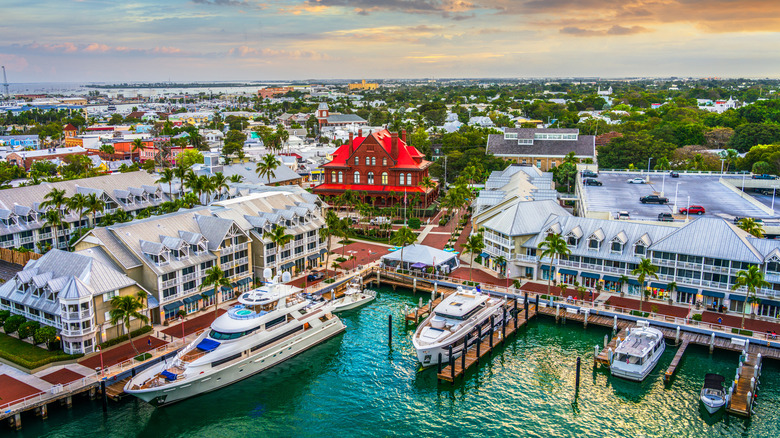 Aerial view of Key West, Florida with coastal hotels, yachts, and bright turquoise water visible at sunrise