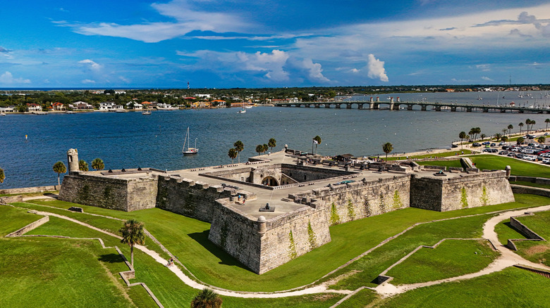 Aerial view of Castillo San Marcos fort in St. Augustine, Florida on a sunny day with water, homes, and sailboats in the background