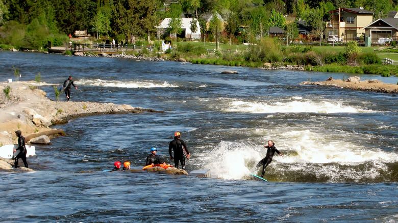 A group of people river surfing at Bend Whitewater Park