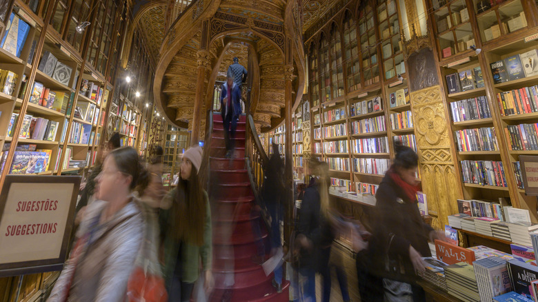 Wall-to-wall bookshelves with spiral staircase inside Livraria Lello