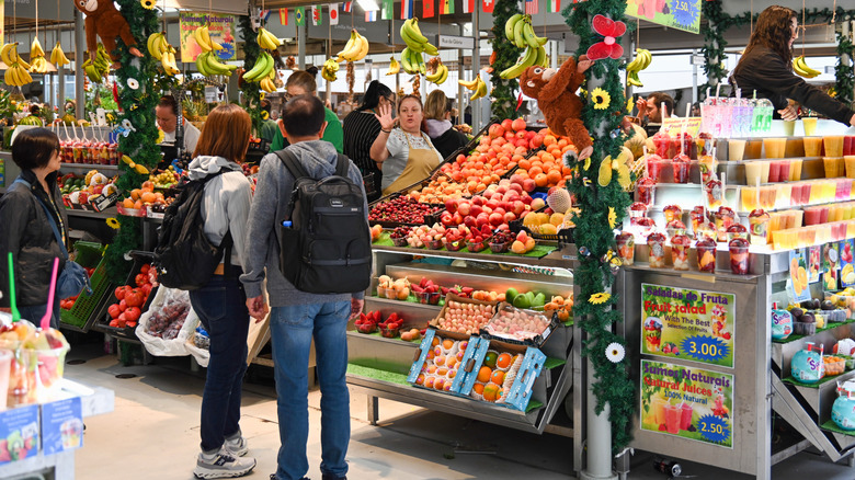 People shopping at a fruit stall in the Bolhão Market