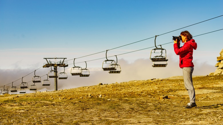 Traveler taking a photo in front of the chairlift at Serra da Estrela