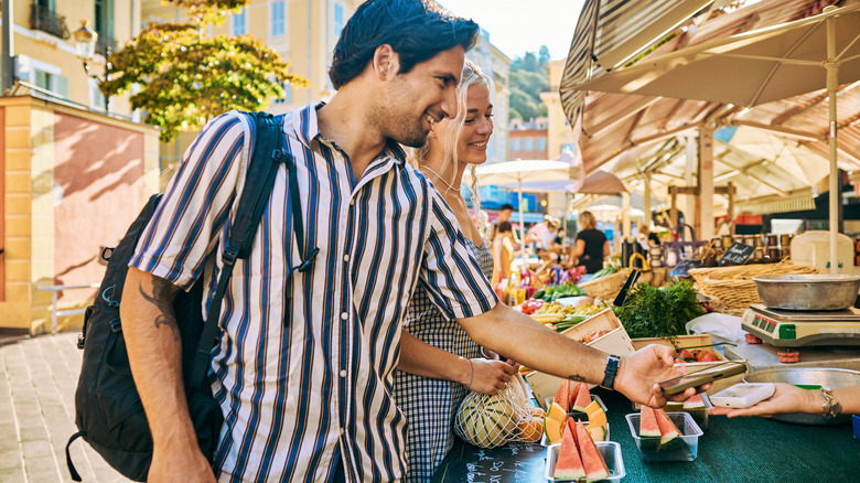 A couple shopping at a farmers market in Provence