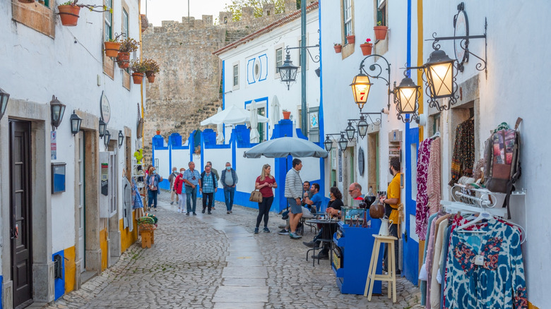 People shopping in Óbidos, Portugal near the castle wall