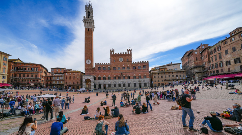 People relaxing in Piazza del Campo in Siena, Italy