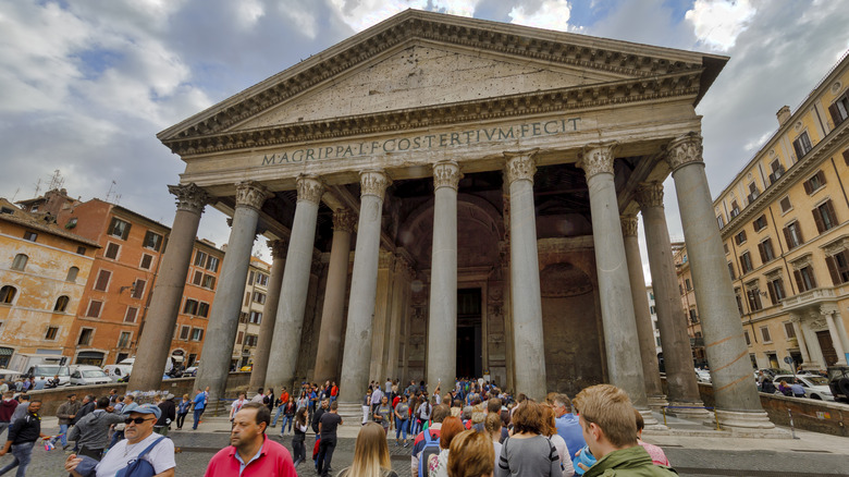 A building with tall columns, with tourists gathered in front