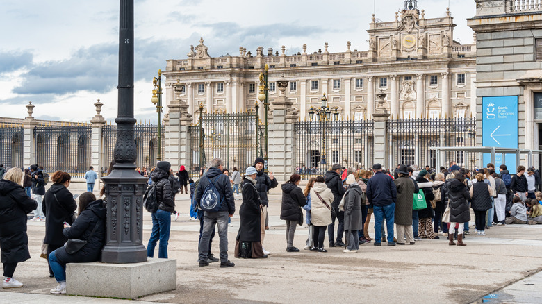 Long queue of people waiting to buy tickets and enter Royal Palace of Madrid.
