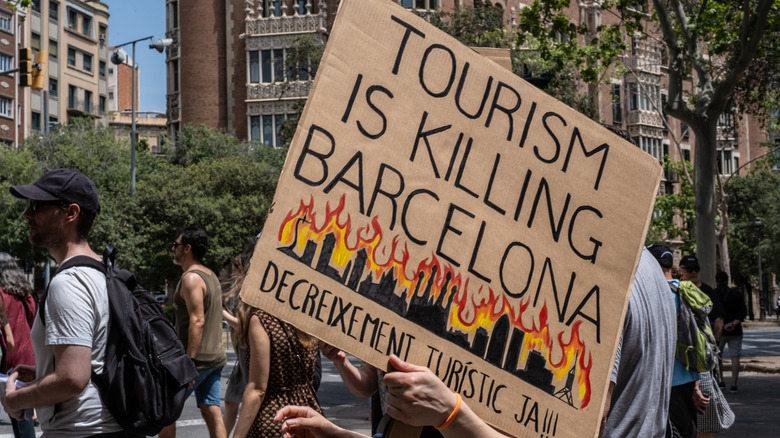 Person holding a sign at an anti-tourism protest in Barcelona, Spain