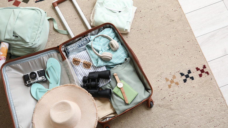 An open suitcase with clothing and accessories