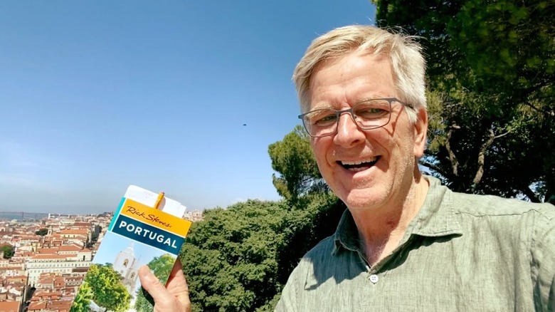Rick Steves holding a guidebook in Portugal