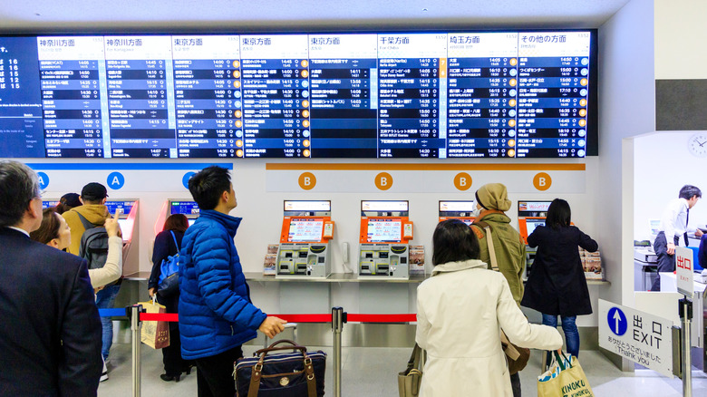 people in line waiting to purchase tickets at an airport counter