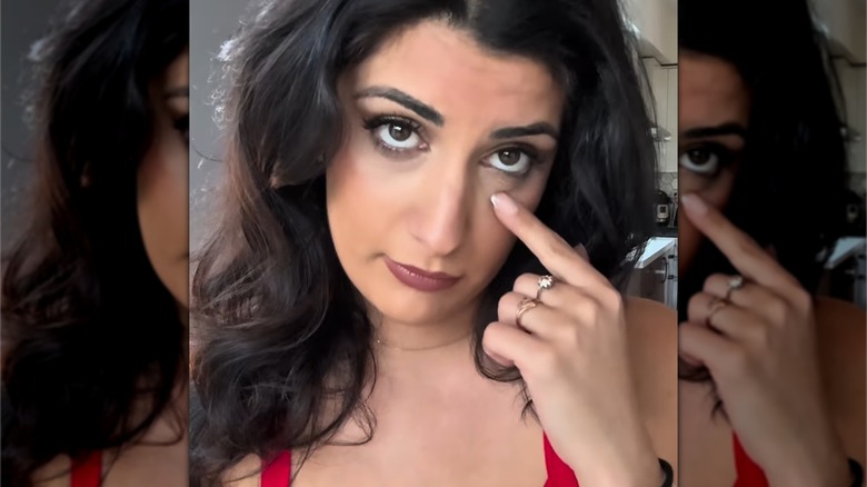 Someone doing the eyelid pull gesture