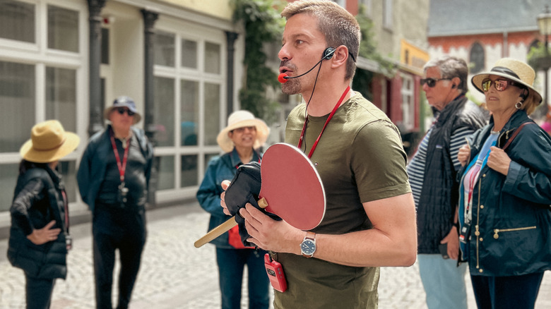 A tour guide leads a tourist group on a walking tour of a historic city.