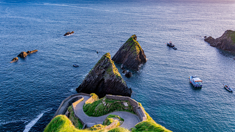 Dunquin Pier with sharp rocks and a road going to the ocean along Ireland's Dingle Peninsula
