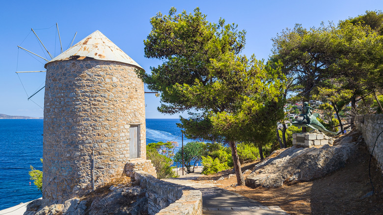 Traditional windmill along a coastal path in Hydra, Greece