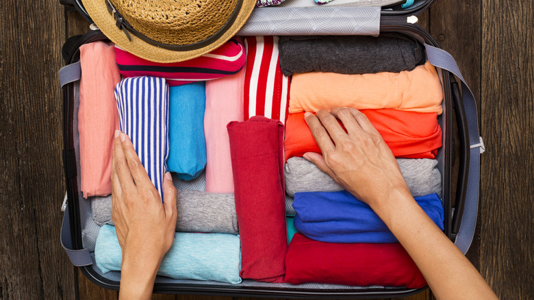 Traveler neatly packing a suitcase