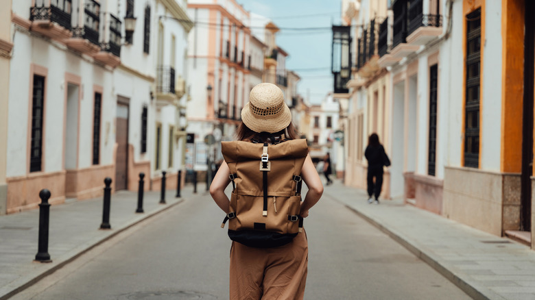 Traveler with backpack walking down a street