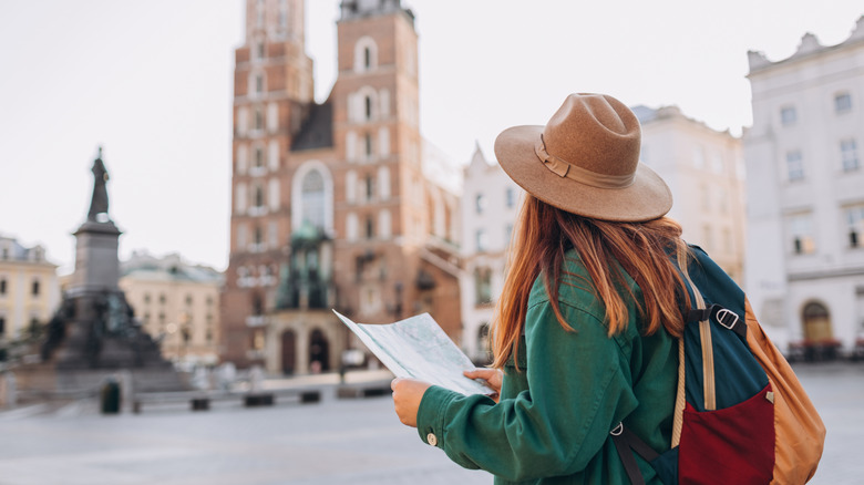 Backpacker holding a map in square in Krakow, Poland