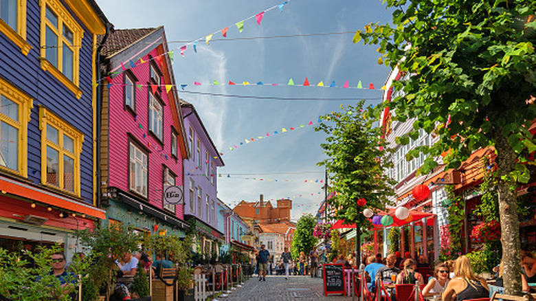 Old Town in Stavanger, Norway, with colorful buildings and flags hanging over the road