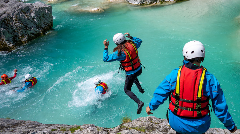 Canyoneers diving into the blue waters of the Soca River, Slovenia