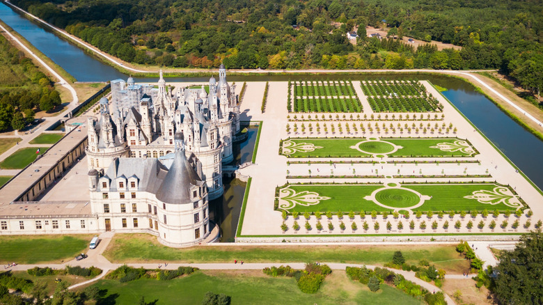 An aerial view of Château de Chambord and its landscaped grounds, surrounded by a moat