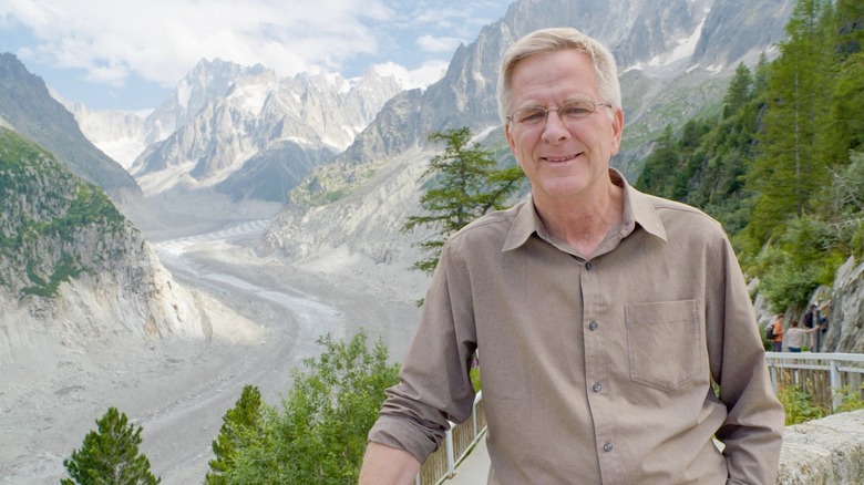 Rick Steves in the French Alps, with the mountains behind him