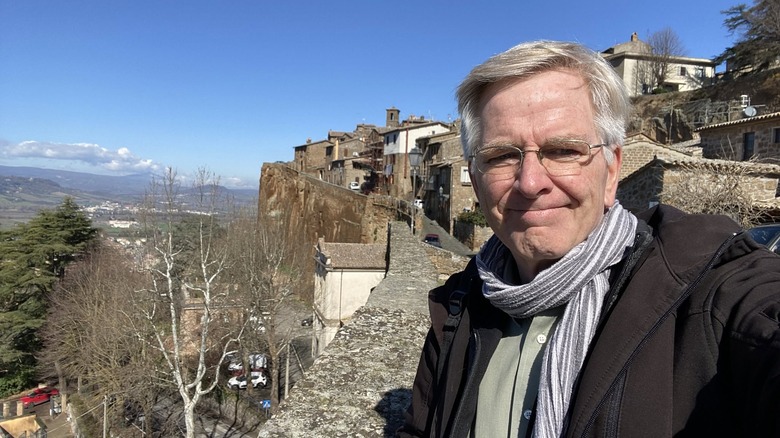 Rick Steves in Italy, taking a selfie at a viewpoint