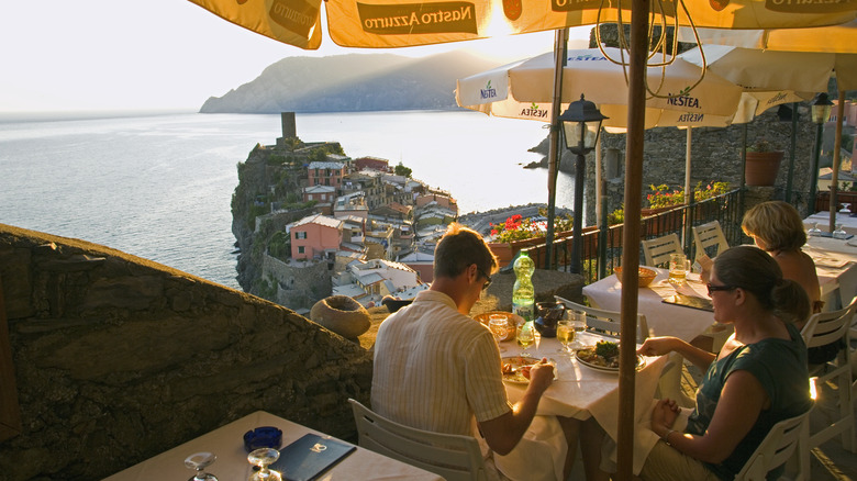 people eating at a restaurant terrace at the coastline