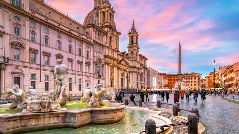 Piazza Navona fountain and historic buildings at sunset.