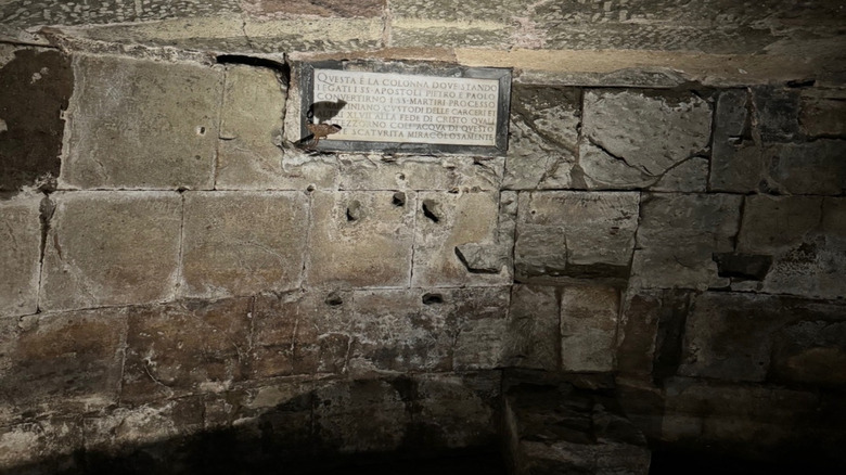 Plaque and stone walls inside the prison pit at Mamertine Prison, Rome