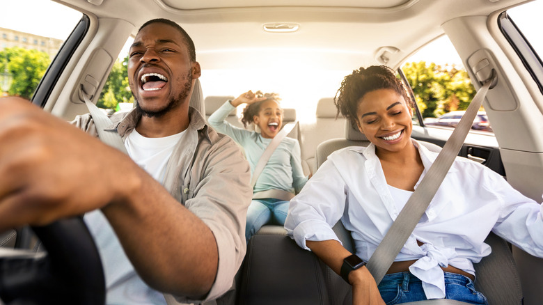 Smiling family in a car on a road trip