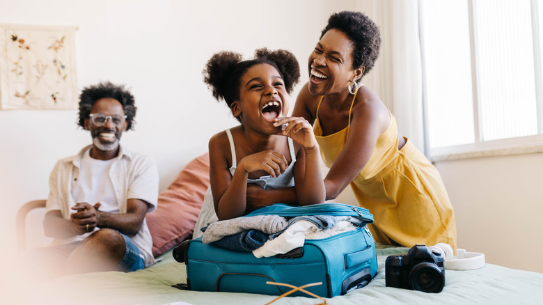 Laughing family packing for vacation