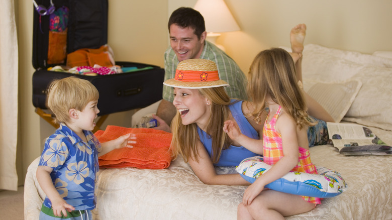 Smiling family in a hotel room wearing summer clothes