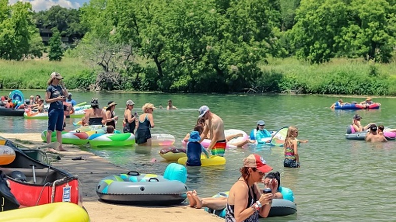 People float in tubes at Cypress Creek swimming hole in Wimberley, Texas.