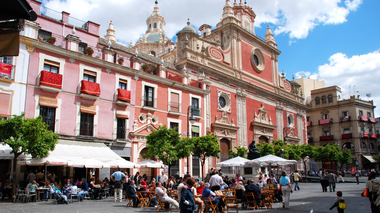 Tourists relax a tables outside of Iglesia Colegial del Divino Salvador