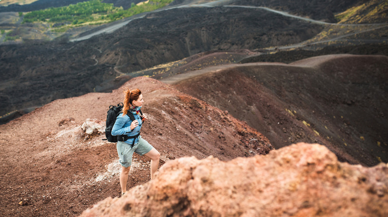 A hiker stands on Mount Etna