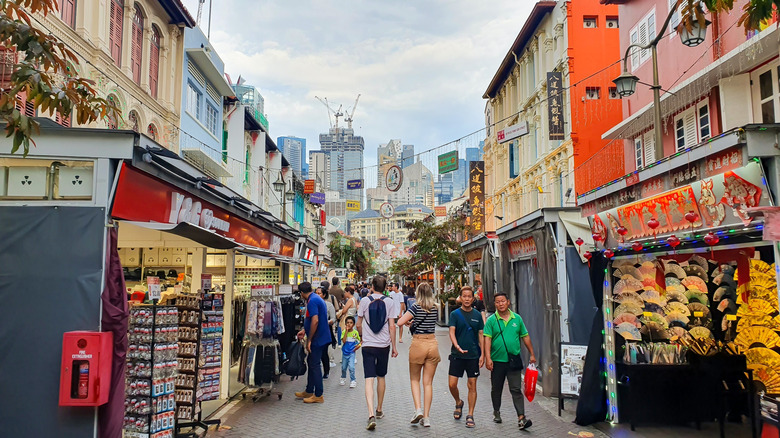 Travelers walking along market stalls in Chinatown, Singapore