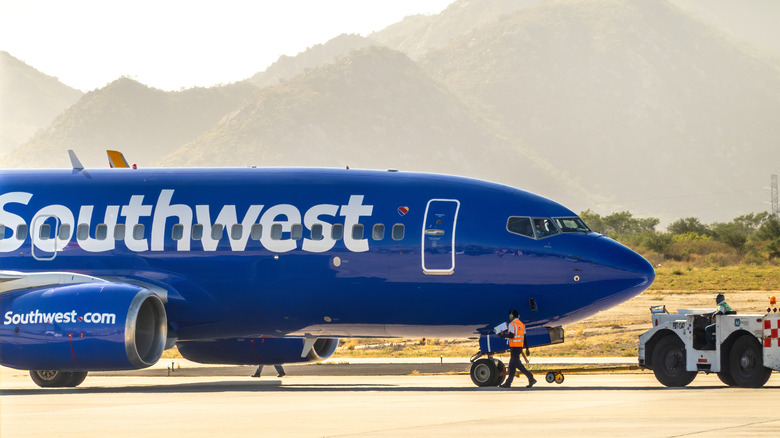 A Southwest plane on the runway in Los Cabos, Mexico with mountains in the background.