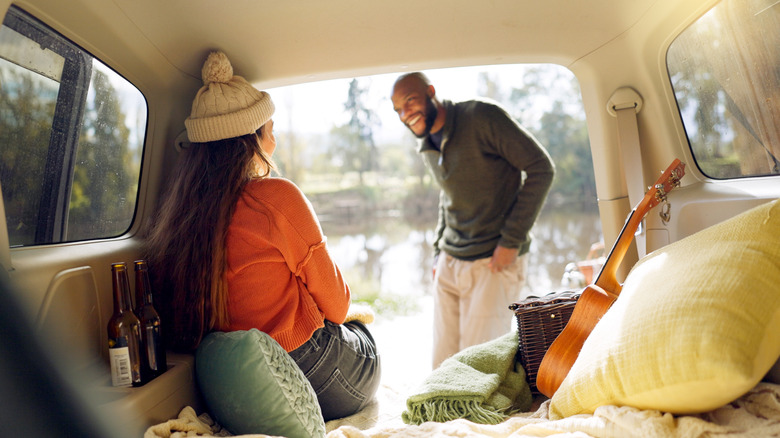 A man and woman fully dressed for winter in a camper van