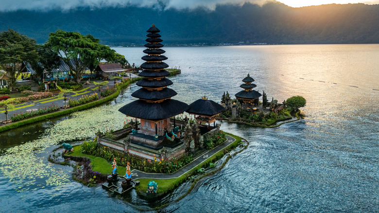 Scenic view of Pura Ulu Danau Temple set on a peaceful lake in Bali, Indonesia.