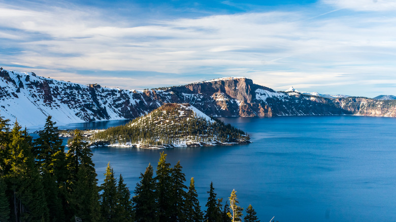 Winter view of Crater Lake National Park with snow, with Wizard Island and pine trees visible