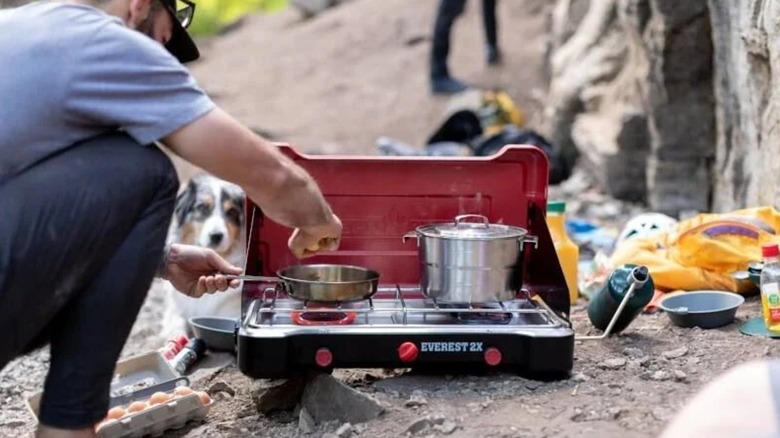 A man uses a Camp Chef Everest 2X camp stove