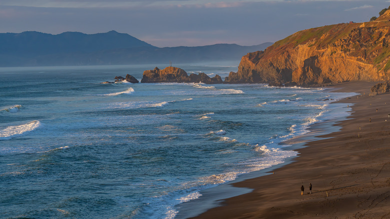 Golden hour at Esplanade Beach with waves crashing into the sand