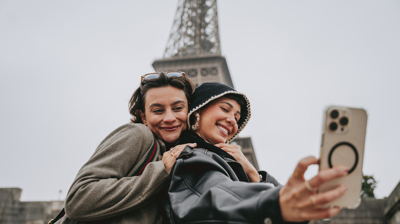 Tourists in Paris posing by the Eiffel Tower