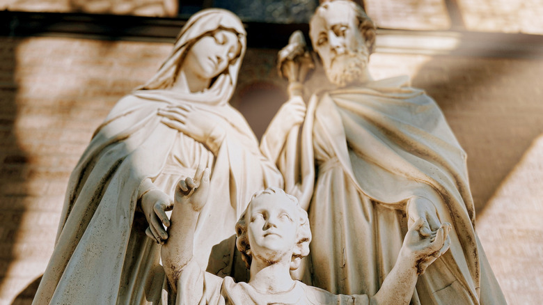 A serene statue of the Holy Family bathed in sunlight outside Our Lady of the Holy Family Catholic Church in Chicago's Little Italy.