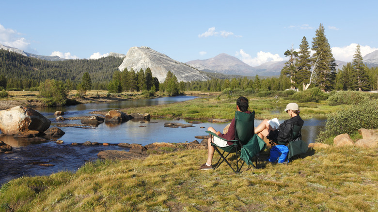 Two people relaxing on the banks of the Tuolumne River in Yosemite National Park