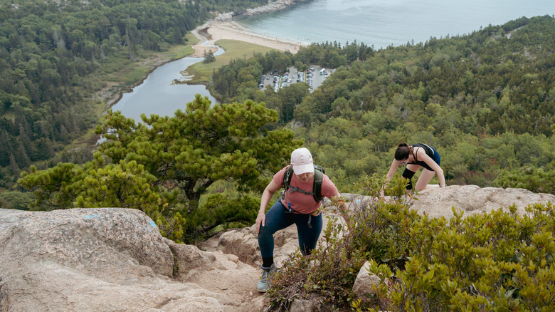 Two female hikers climb a mountain Acadia National Park